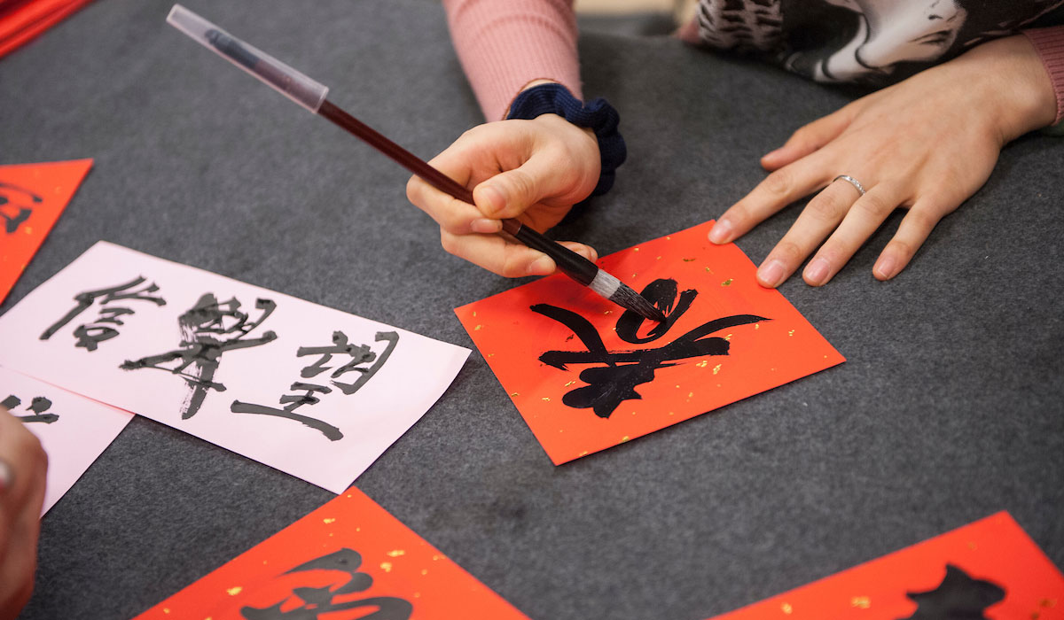 Hands writing Chinese characters